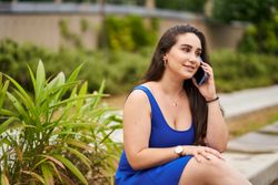 A woman sitting in a park talking on the phone