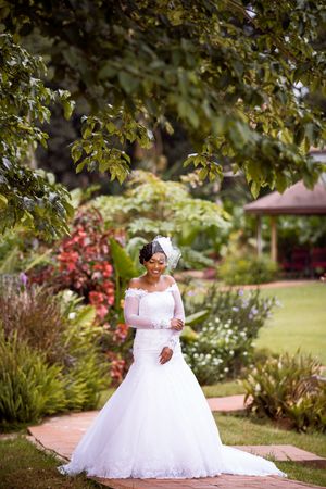 Bride posing beside tree in a garden