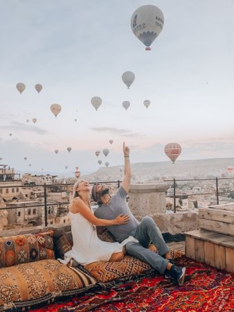 Man and woman looking at hot air balloon in sky
