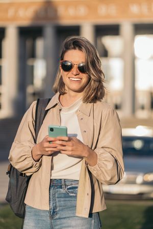 student watching mobile in college. Blonde girl