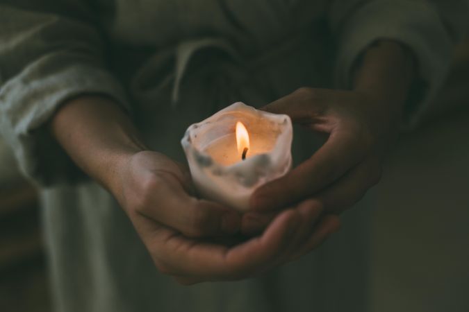 Close up of person holding lit candle