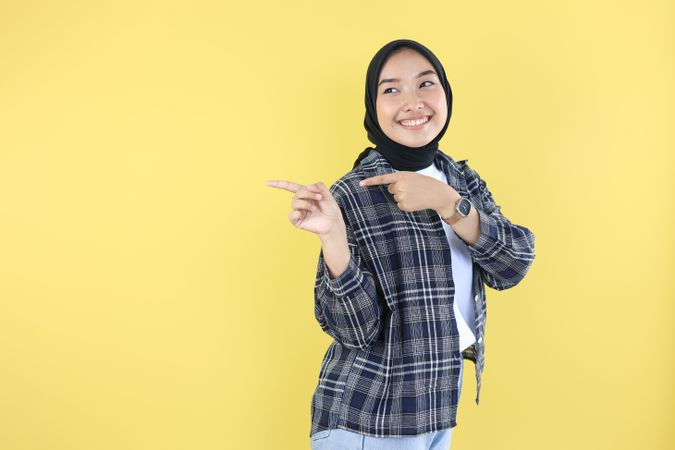 Young Muslim Woman Wear Hijab Headscarf Smiling and Pointing Finger