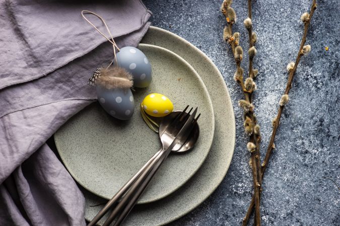 Easter holiday table setting with top view of decorative eggs on grey plate