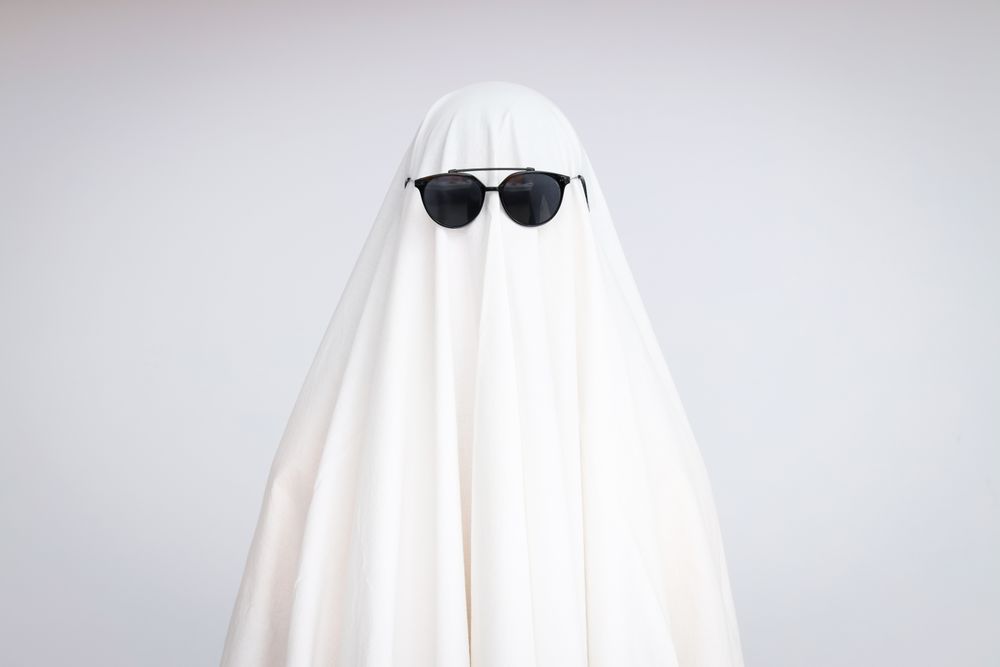 Concept of Halloween, Ghost with sunglasses on light background