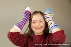 Happy young child wearing striped socks on her hands 4MP1G5