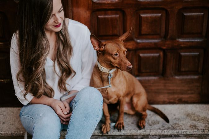 Woman with purebred dog on stone porch
