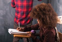Multiracial teacher and pupil in classroom at math lesson