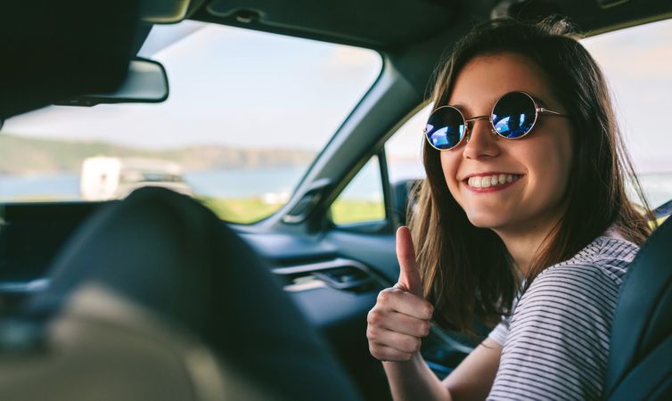 Woman doing thumbs up in the car