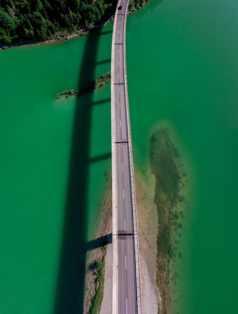 Drone image with the bridge over Sylvenstein Lake in bright light, on a sunny day in summer