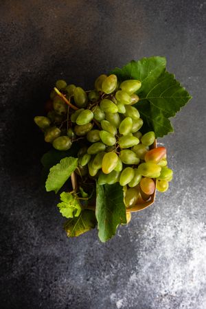 Box of fresh green grapes on grey kitchen counter