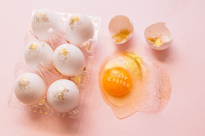 Easter eggs in box and broken egg on table