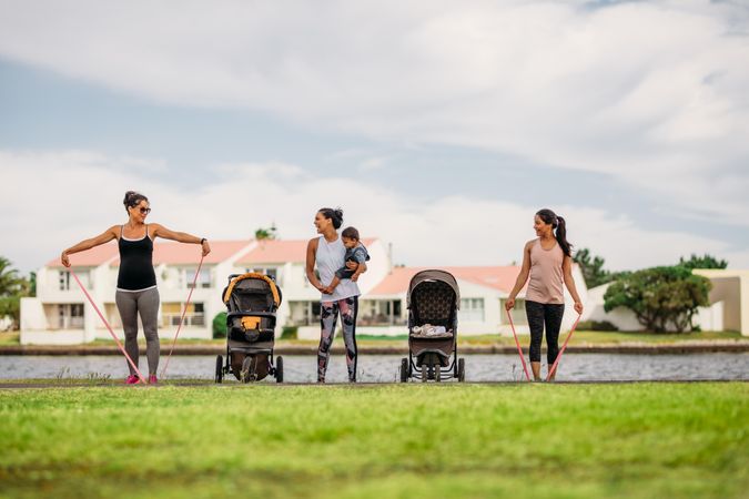 Women doing workout in park bringing their kids in strollers