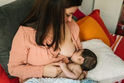 Mom breastfeeding at home