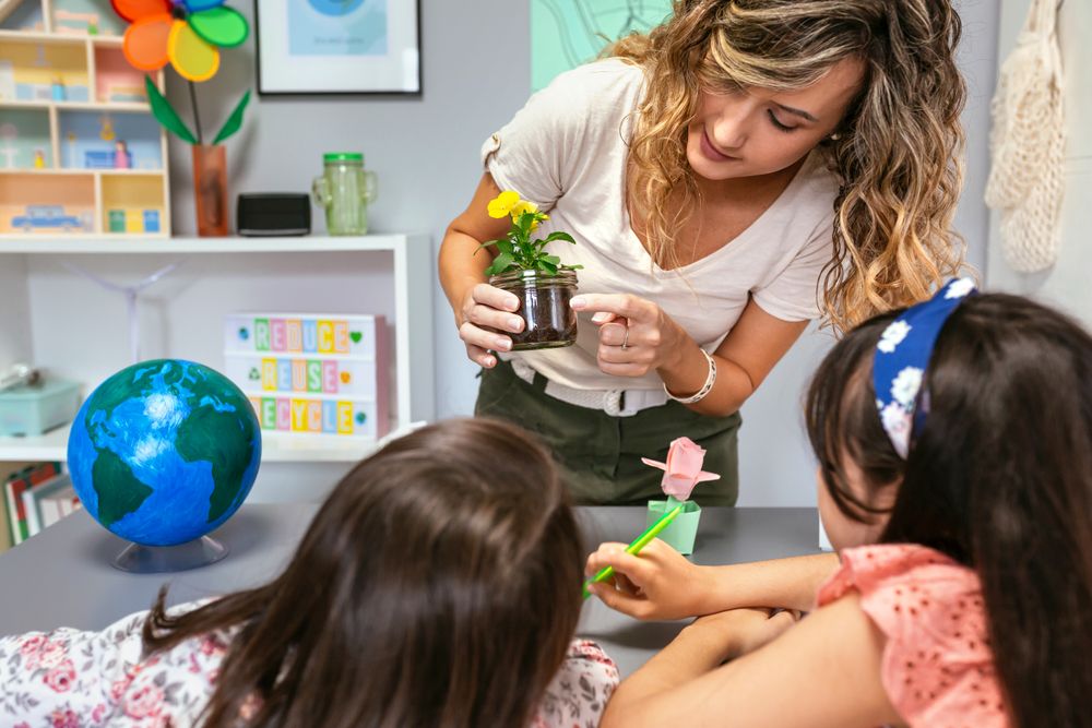 Female teacher showing pansy plant roots to her students in ecology classroom