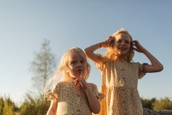 Happy sisters enjoying summer evening in countryside