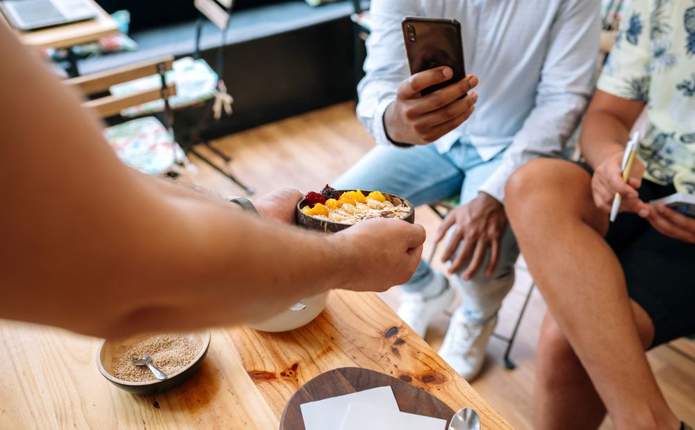 Chef showing healthy bowl to food bloggers and influencers taking photos in cooking master class