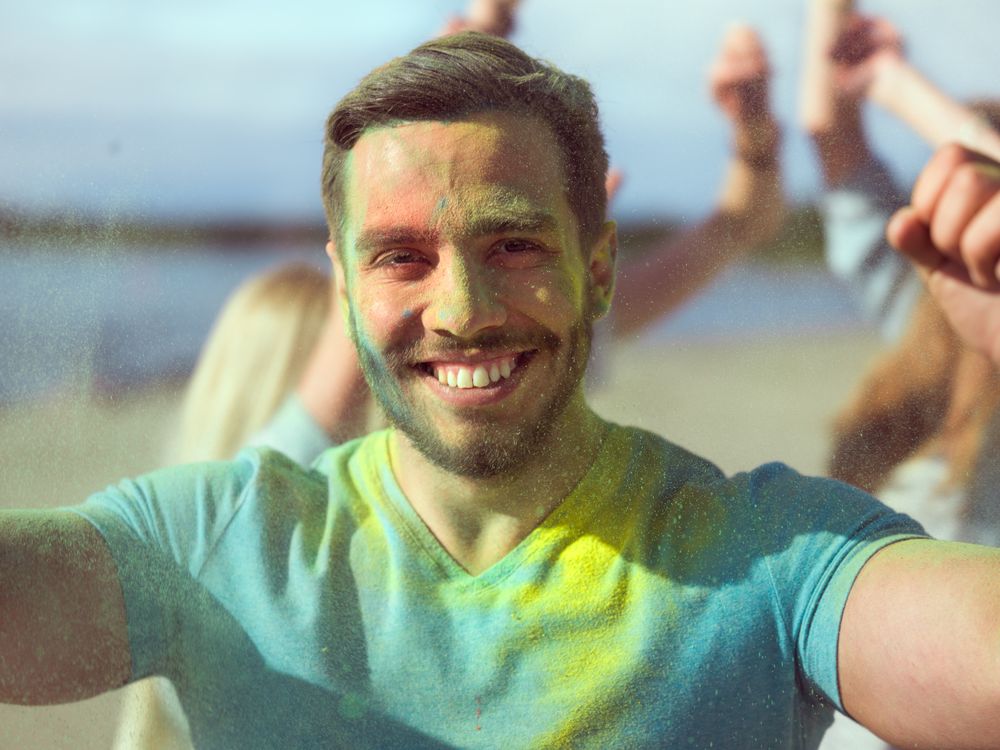 Selfie Portrait of a Muscular Man Celebrating of Holi Festival With His Friends.