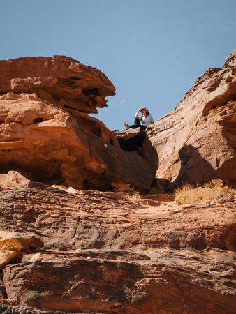 Woman sitting on rough cliff