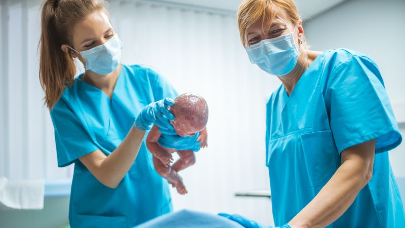 In the Hospital Midwive Holding Newborn Baby