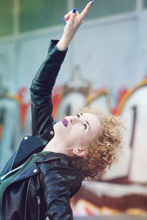 Smiling woman with curly hairstyle and leather coat