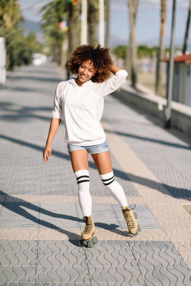 Happy woman on roller skates with her hand in her hair
