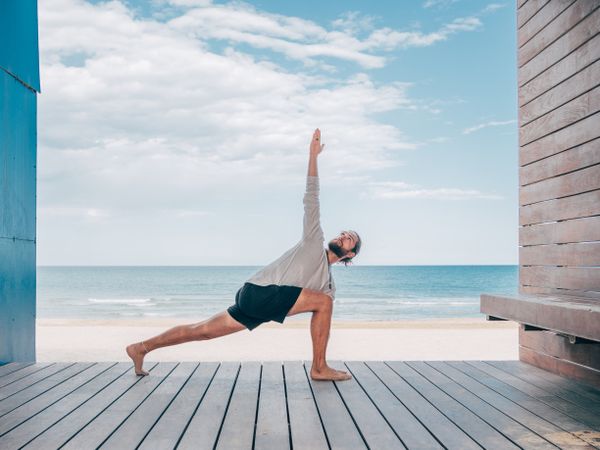 Man doing yoga by the beach