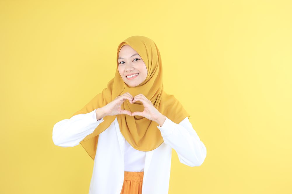 Young Asian Indonesian Woman with Casual Hijab Fashion Making Heart Shape with Her Hand