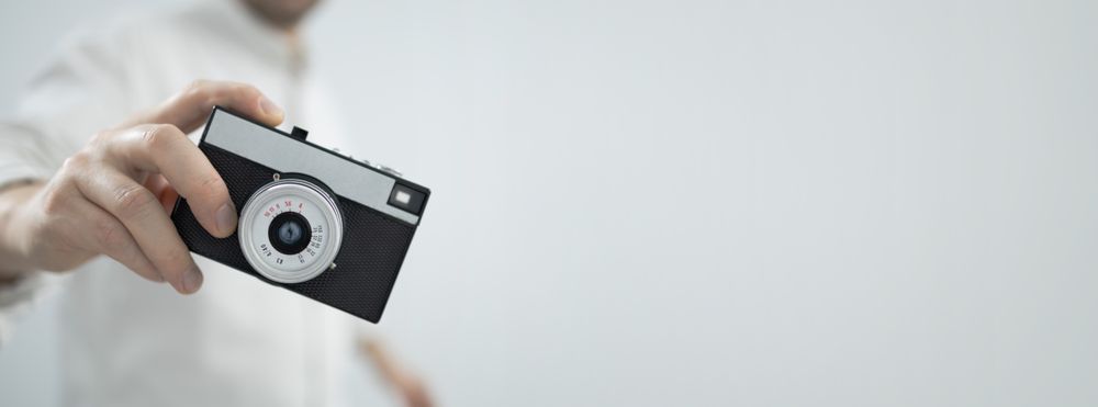 Young man holding retro camera
