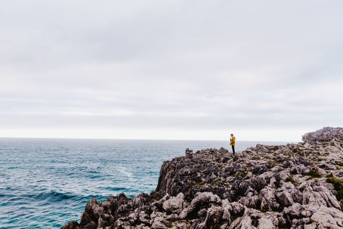 Traveler in solitude walking on rocky shore