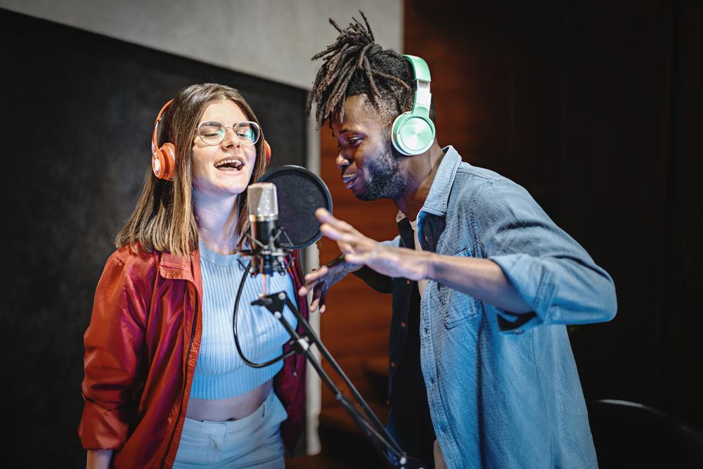 Couple of young people performing a vocal live session online streaming by the internet