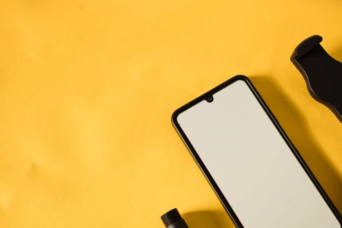 Mock up phone on yellow table with shadow and copy space