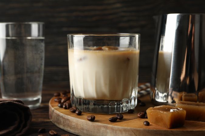 Composition with ice coffee and coffee seeds on wooden background