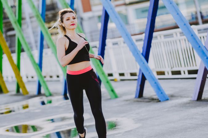 Woman with earphones running on street