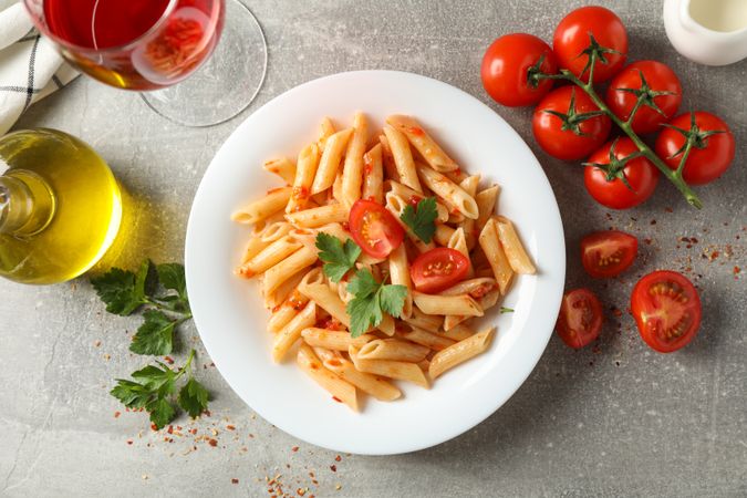 Composition with plate of tasty pasta on gray background, top view