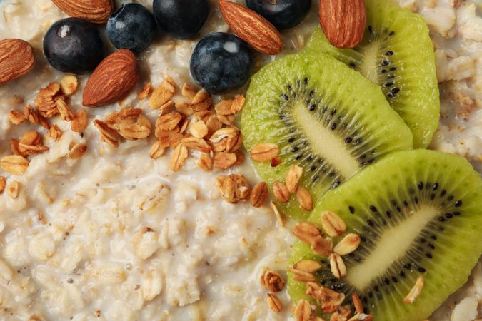 Oatmeal porridge with fruits on whole background, close up