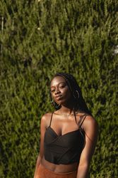 Portrait of a young Black woman with braids in her hair as she enjoys the afternoon in the park