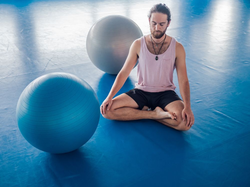 Male meditating in spacious room