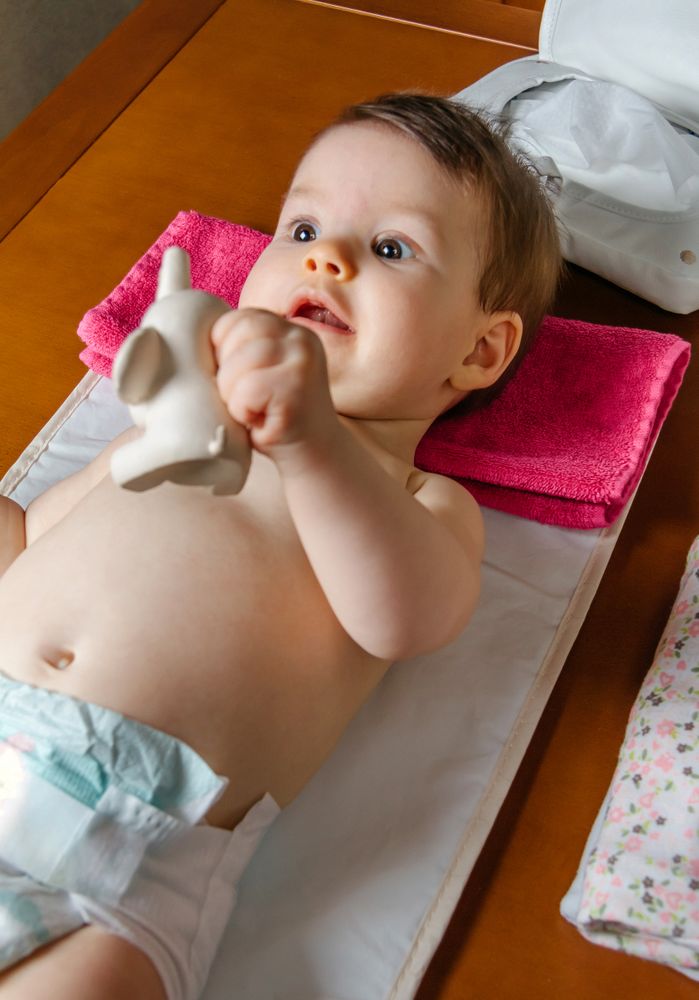 Adorable baby lying playing with a rubber toy