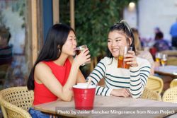 Two women sitting in restaurant patio with drinks 5wQzLb