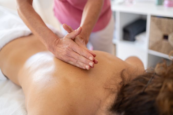 Hands of physical therapist working on client's back