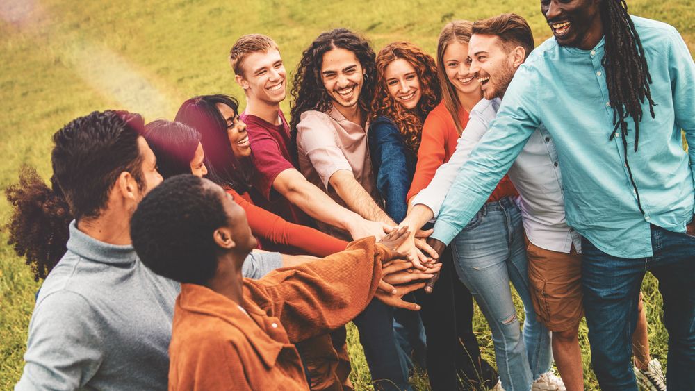 Friends joining hands in circle outdoors