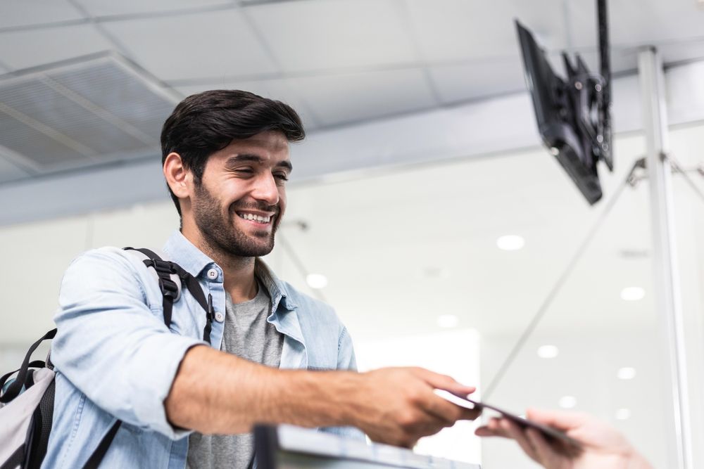 Male giving his ticket to person behind desk