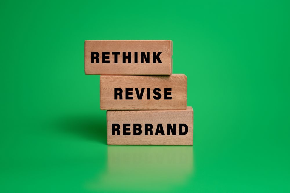 rethink revise and rebrand words on wooden blocks isolated on green background