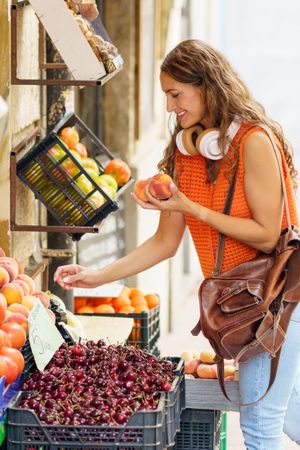 Woman buying fruit in small local shop