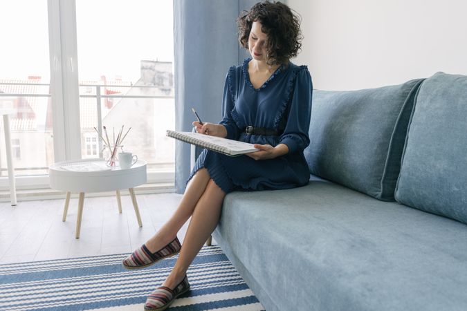 Woman artist drawing at sofa