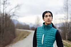 Young woman looking to her right while standing on a trail