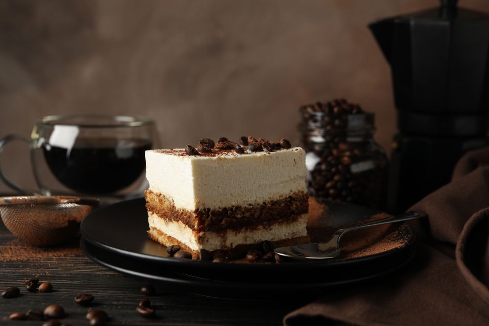 Composition with tasty tiramisu and coffee on wooden background