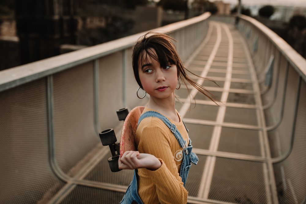 Girl with skateboard on walkway