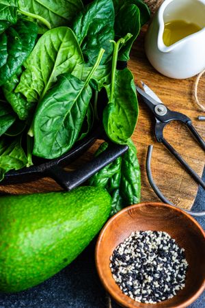 Fresh spinach leaves & avocado in kitchen with oil and seasoning