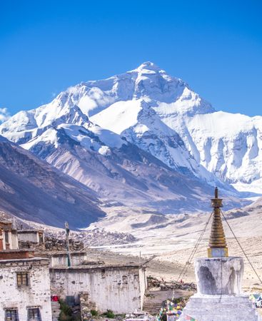 Shabby houses and temple near snowy mountain